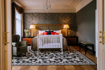 Ložnice s dětskou postýlkou v apartmá Premier Suite v Grandhotelu Pupp