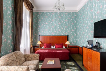 Superior Room front view with green wallpaper at the Grandhotel Pupp