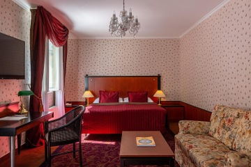 Superior Room front view with red wallpaper at the Grandhotel Pupp